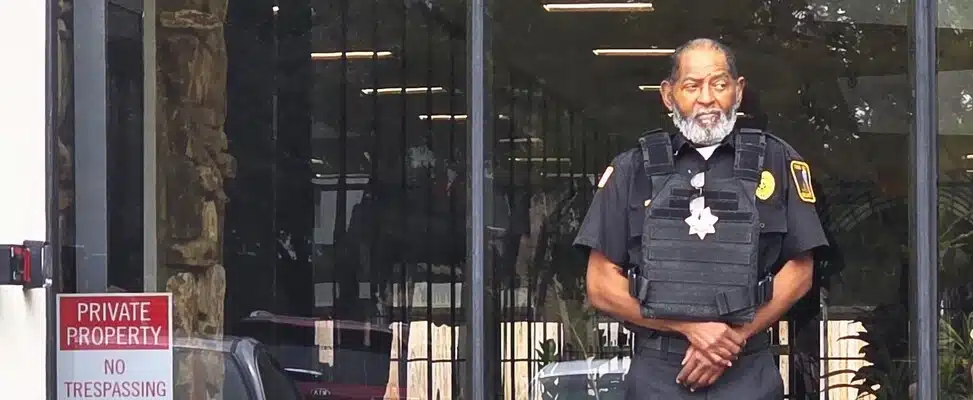 doorman-security-kansas-img-1 Security guard standing outside building entrance.