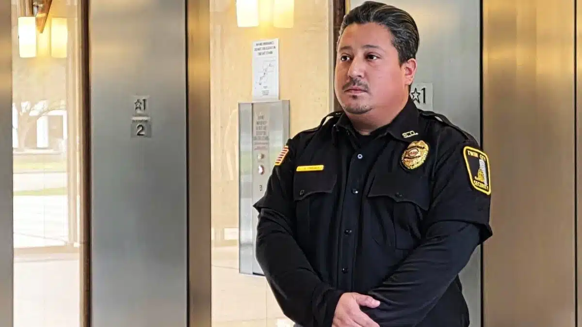 Security guard standing by elevator doors.